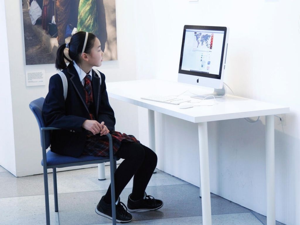 A girl looks at a computer presentation on forests.