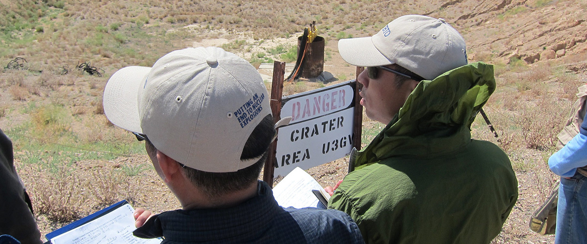 巡视专家站在美国内华达试验场一座地下核爆炸场弹坑附近。图片： 禁核试组织官方图片库