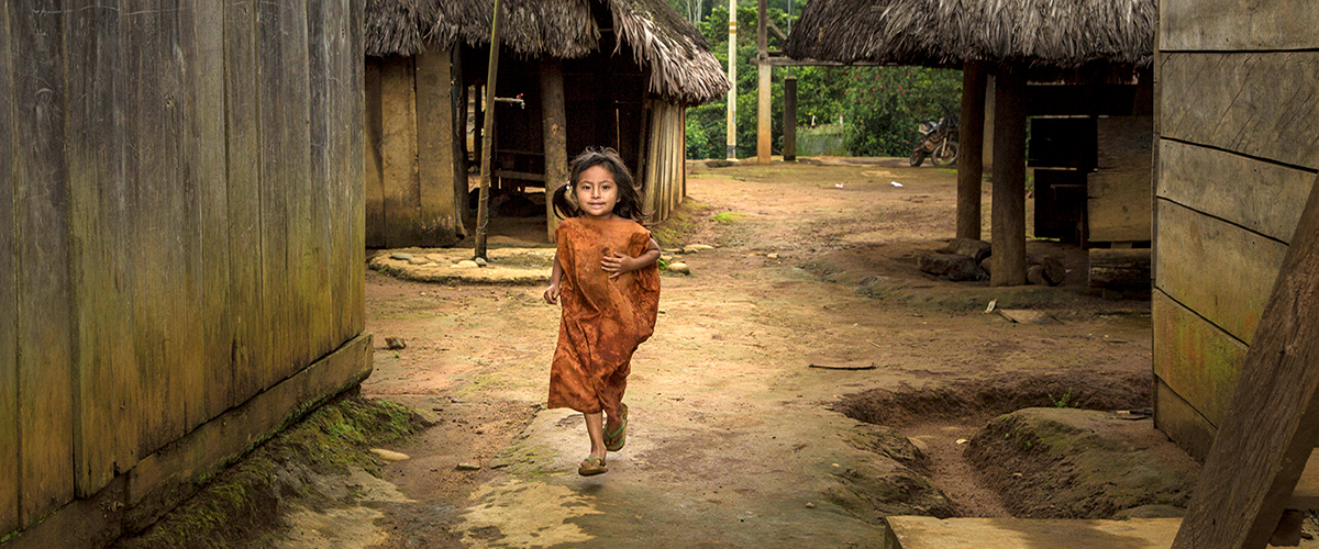 在秘鲁潘戈阿地区，一个小女孩跑过一家咖啡合作中心。该中心与当地土著群体有合作关系。开发署秘鲁办事处图片/Mónica Suárez