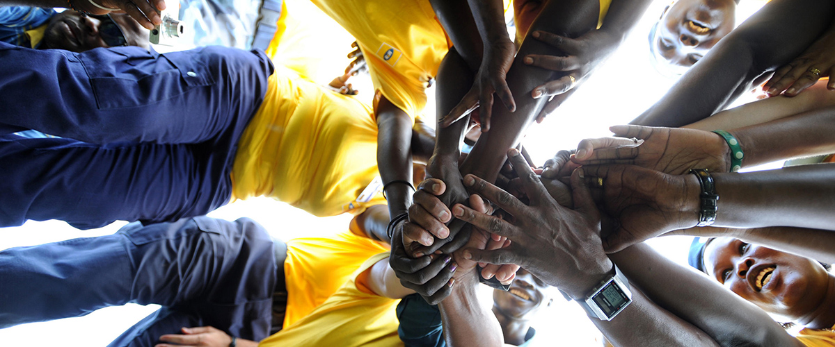 在国际和平日举行的庆祝活动上，参加拔河比赛的联合国警察和南苏丹警察局成员把手握在一起以示友谊。
