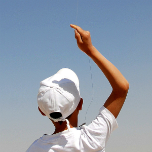一名在国会大厦的山顶上放风筝的阿富汗少年。在阿富汗,儿童们很流行放风筝。 联合国图片/ Helena Mulkerns