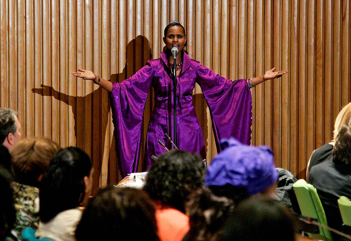 Jacqueline Murekatete (standing), a genocide survivor and activist for Miracle Corners of the World, speaks at the commemorative event.